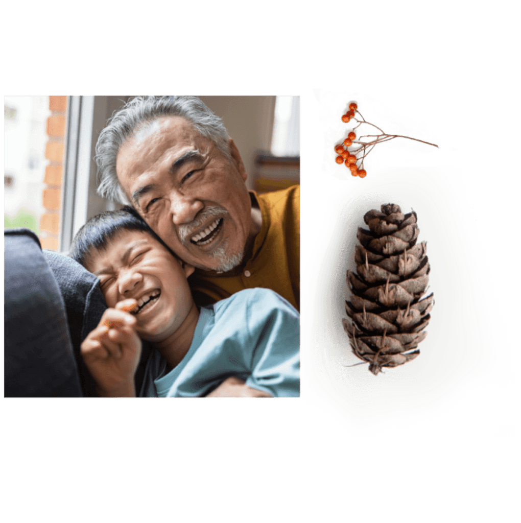 An elderly man and a child share laughter indoors at Suncadia Resort, Washington. A pine cone is displayed to their right, reminiscent of the natural beauty surrounding Cle Elum restaurants nearby.