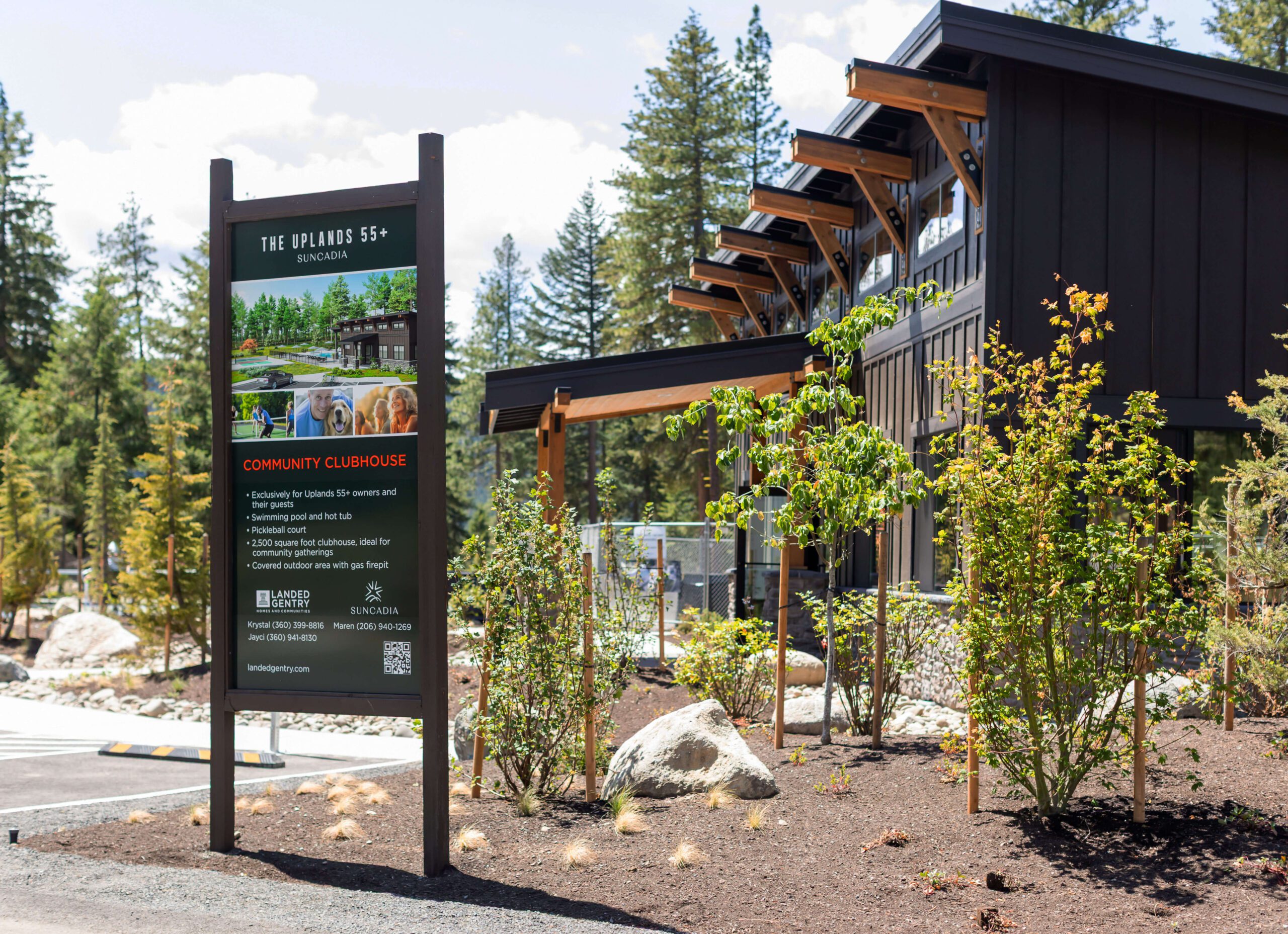 A clubhouse building with a sign in front reading "The Uphill 55+" and "Community Clubhouse," surrounded by trees and landscaping.